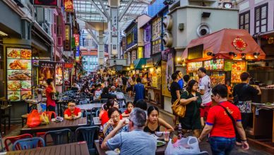 Vibrant Singapore nightlife with illuminated skyline, bustling streets, and people enjoying local food and shopping